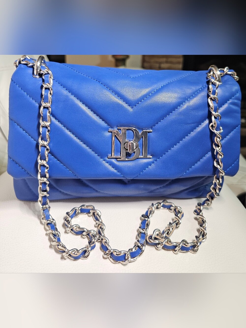 Blue Badgley Mischka quilted crossbody bag featuring a silver chain strap
